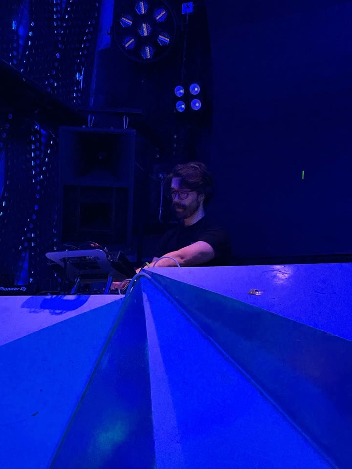 F3R tocando en la cabina de Octava frente a la consola, bajo luz azul